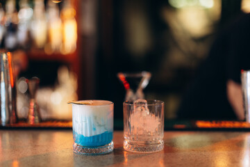Closeup of Two Cocktails Displayed on a Bar Counter in a Dim Setting