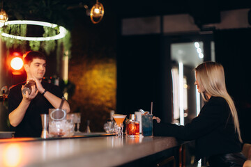 Bartender Preparing Cocktails for Patron at Modern Trendy Bar