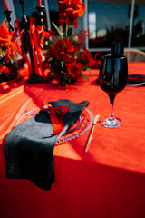 Elegant red table setting with roses and candlelight for a romantic dinner event