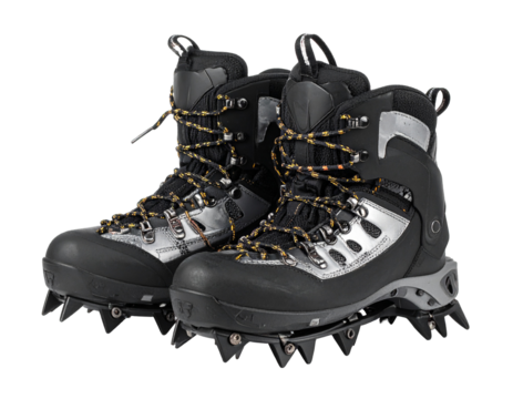 A pair of metal crampons with straps, angled view, essential traction gear for ice climbing and mountaineering, isolated on white.
