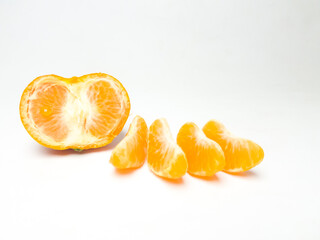 Fresh orange slices and a halved mandarin on a clean white background. Juicy and vibrant citrus...