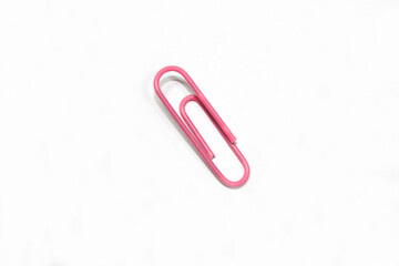 Pink paper clips isolated on white background. Paper clips background texture.