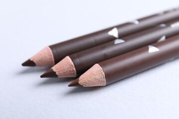 Three eyebrow pencils on white background, closeup