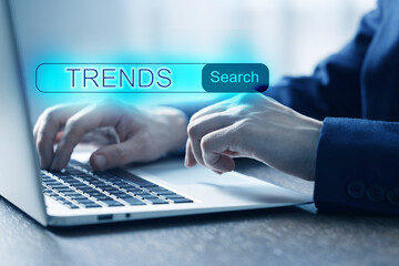 Businessman using laptop to find hot tendencies, new ideas, popular directions at table, closeup....