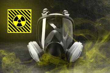 Radiation threat. Gas mask, radioactive sign and smoke on grey table