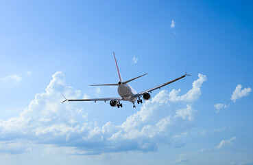 Airplane flying in beautiful blue sky with clouds