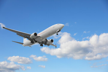 Airplane flying in beautiful blue sky with clouds