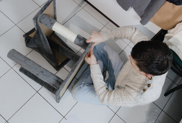 One person is assembling a new cat house at home.