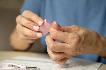 Nail care at home, close-up manicure. Using cuticle nippers, a nail file, a sanding pad, a brush...