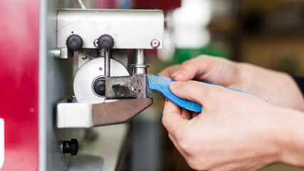 Leather crafting process on machine in workshop