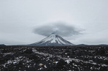 Majestic snow capped mountain peak shrouded in dramatic clouds