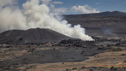 Volcanic landscape with black rock and steaming vents