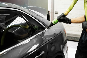 High-pressure air is directed at tight vehicle seams to remove lingering water after washing,...