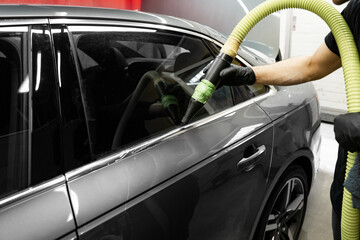 High-pressure air is directed at tight vehicle seams to remove lingering water after washing,...