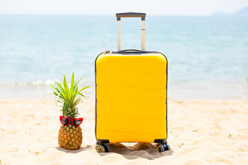 Summer tropical vacation concept, The sweet pineapple wearing a red sunglasses and yellow suitcase...