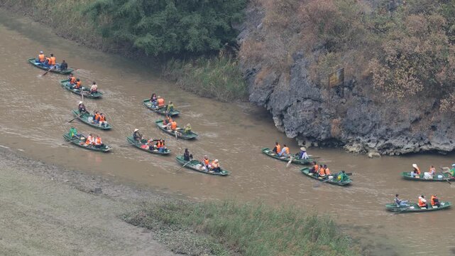 People Enjoying Scenic Boat Ride on Ngo Dong River in Tam Coc, Ninh Binh Vietnam Landscape