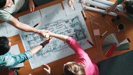 Top view of skilled civil engineer team shaking hand while discussing idea at meeting table with...