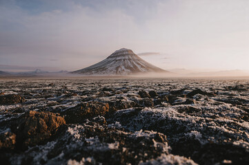 Majestic mountain peak emerges from a rocky misty landscape
