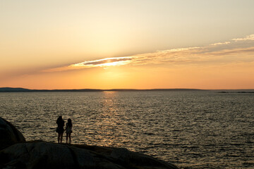Fototapeta premium Enjoying the final moments of a perfect day on the coast at the Peggy's Cove Lighthouse