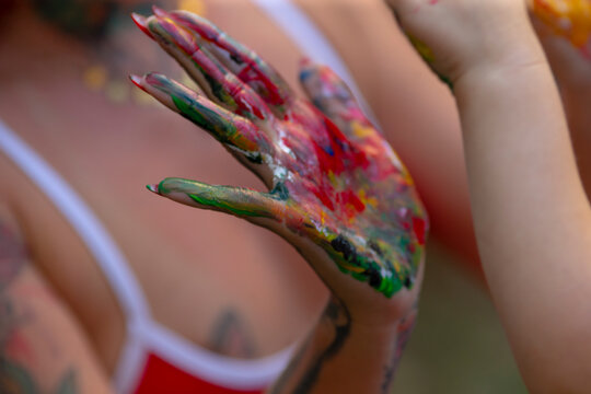 Fototapeta A womans hand is beautifully covered in an array of colorful paint that adds a vibrant touch to her artistic expression and creativity