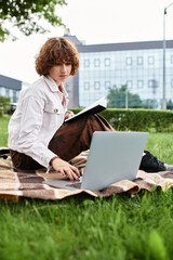 Young woman enjoys remote work in a park under the summertime sun