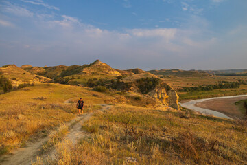 Hiker on the Wind Canyon Trail in Theodore Roosevelt National Park at golden hour