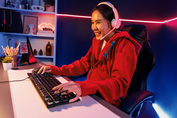 Host channel of smiling beautiful Asian girl streamer playing online game wearing headphone talking...