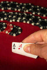 A player holds two aces, showcasing a strong hand in a lively card game. Surrounding them are...