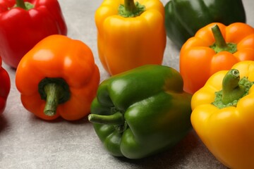 Fresh colorful bell peppers on gray textured table, closeup