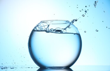 Glass aquarium with water on light blue background