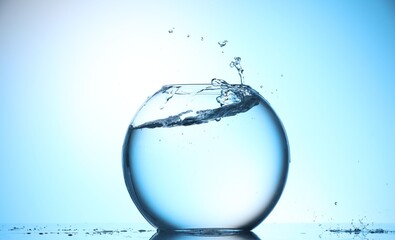 Glass aquarium with water on light blue background