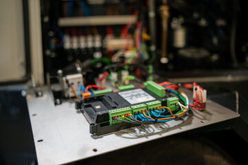 Electronic control board with wiring and connectors inside industrial equipment, closeup of circuit...