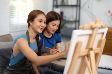 Lesbian couple enjoying painting together in cozy home setting