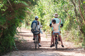 Family Vacation Cycling Activity in Forest Park With Father, Mother and Daughter Enjoying Outdoor Nature Trail Together