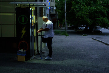 Man using payphone at night on a quiet street in a city