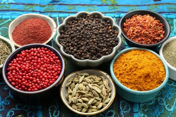 Different aromatic spices on blue tablecloth, closeup