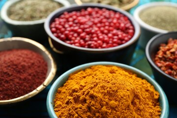 Different aromatic spices on blue tablecloth, closeup