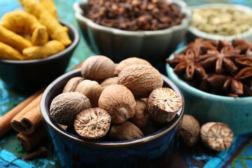 Different aromatic spices on blue tablecloth, closeup