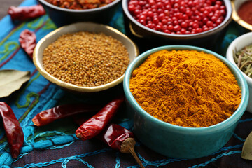 Different aromatic spices on blue tablecloth, closeup