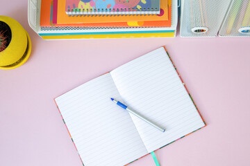 Notebook and stationery on pink background. Back to school concept.