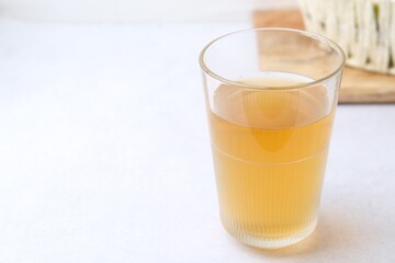 Glass with dirty water on light table, closeup. Space for text
