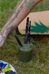 A person who has a tattoo displayed prominently on their arm is sitting comfortably on the grass,...