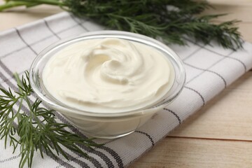 Tasty sour cream and dill on white wooden table, closeup