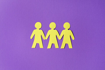 Paper figures of people holding hands on purple background, top view