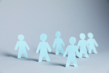 Many human paper figures on light background