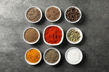 Different aromatic spices on grey table, flat lay