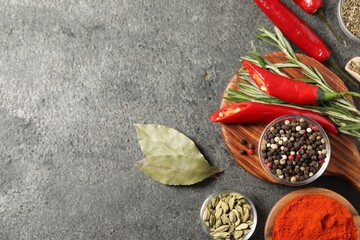 Different aromatic spices on grey table, flat lay. Space for text