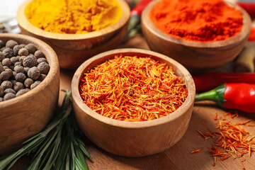 Different aromatic spices on wooden board, closeup