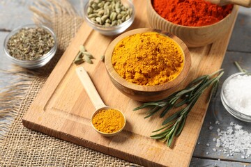 Different aromatic spices on grey wooden table, closeup