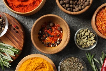 Different aromatic spices on grey table, flat lay